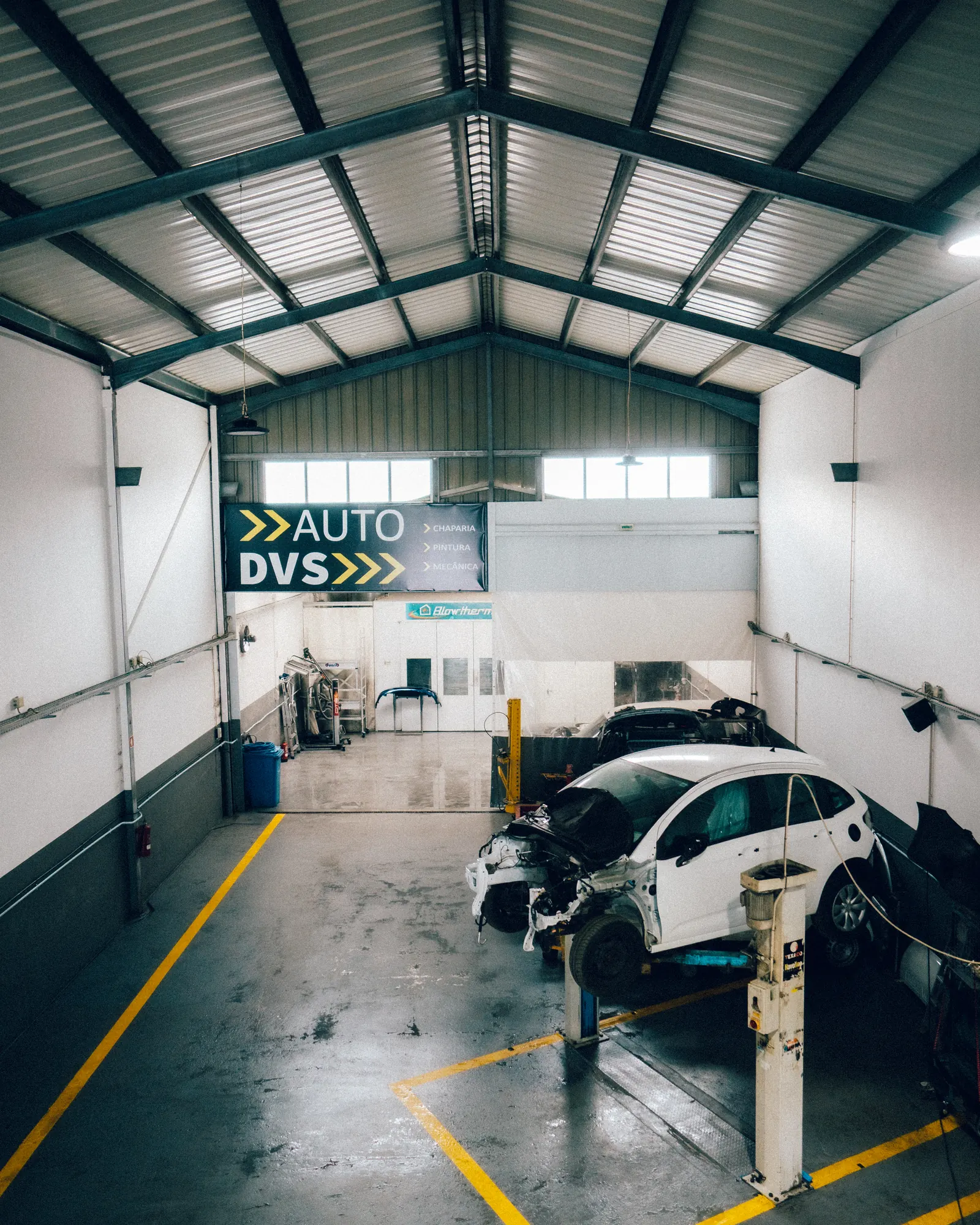 Nave da oficina AUTO DVS com automóveis nos elevadores